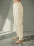 Side view of Deryn Jogger by Boue Clothing in Cream against a stone grey backdrop.