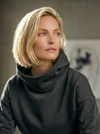 Model wearing Bou Clothing’s Black Marl luxury Deryn hoodie a in a softly lit modern interior, showcasing a relaxed fit, premium fabric, and minimalist neutral style.