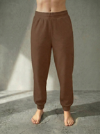 Front view of the Deryn Jogger women’s luxury jogger pants by BOU Clothing in Tan, shown on a model standing barefoot against a beige backdrop.