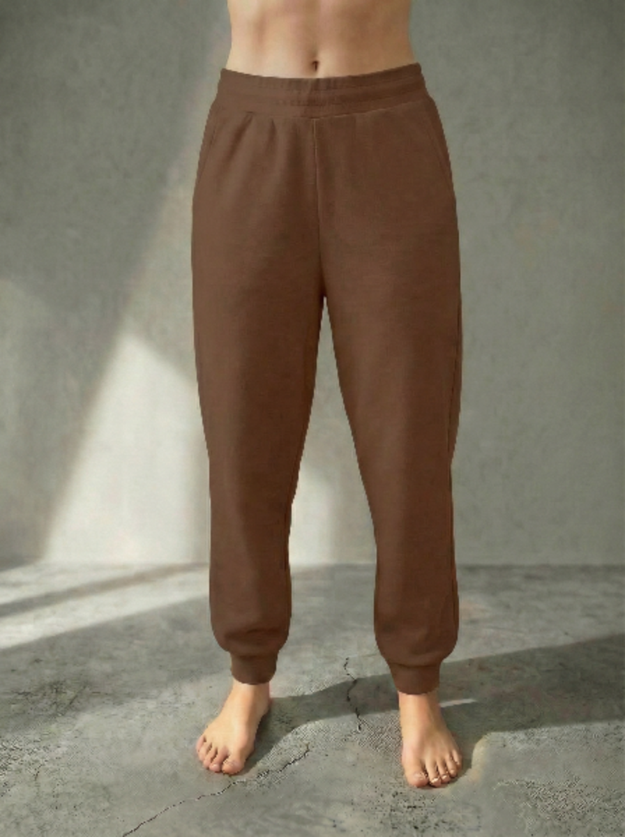 Front view of the Deryn Jogger women’s luxury jogger pants by BOU Clothing in Tan, shown on a model standing barefoot against a beige backdrop.