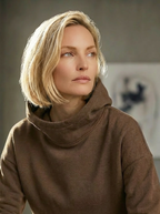 Model wearing Bou Clothing’s Tan Deryn luxury hoodie in a softly lit modern interior, showcasing a relaxed fit, premium fabric, and minimalist neutral style.