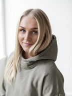 Woman wearing a beige hoodie against a white background