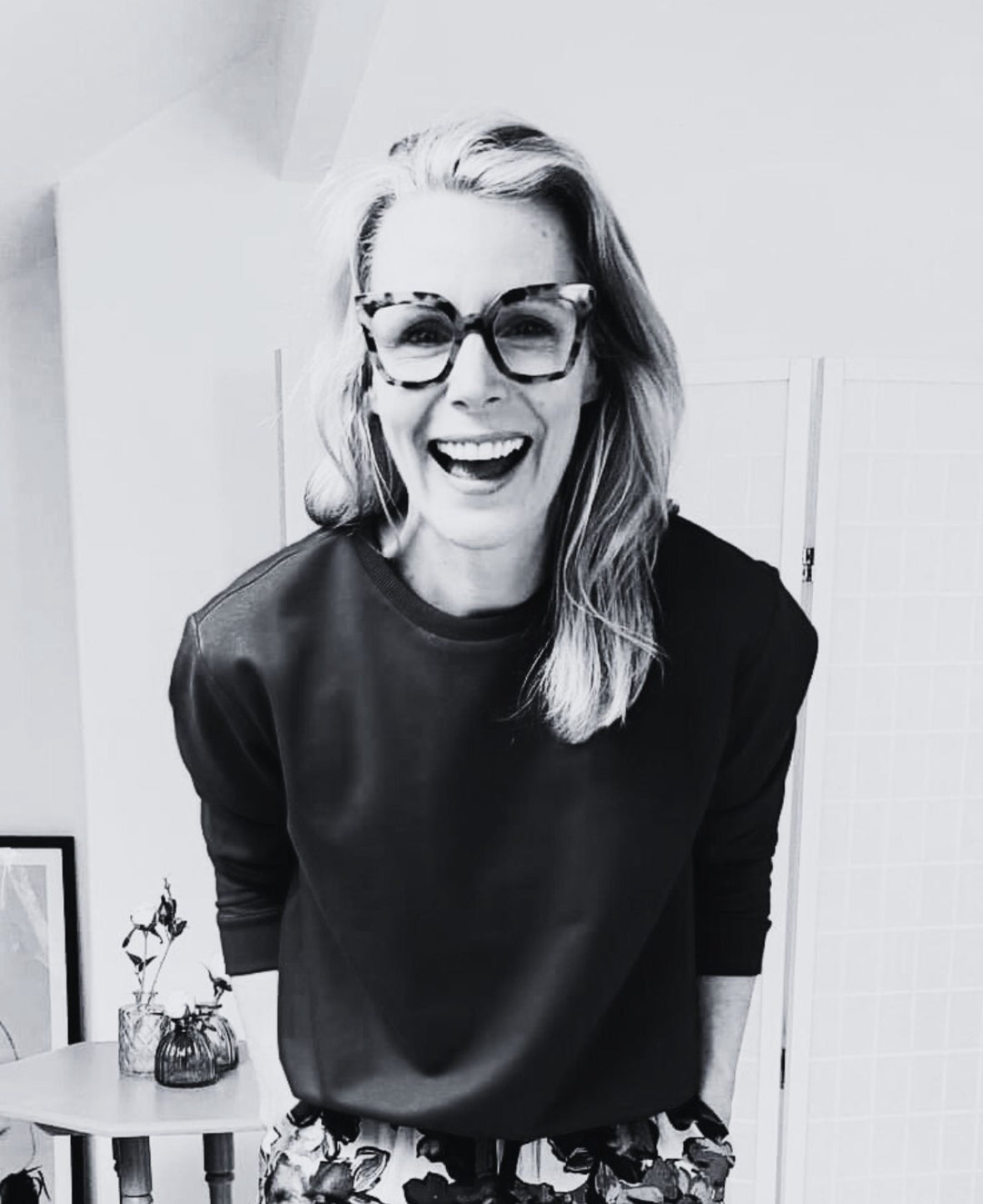 Black and white photo of a woman wearing glasses and a black top. Zilpah Hartley Founder of Bou Clothing