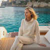 Blonde Woman sitting on a yacht in the wearing a Bou Clothing Cream Deryn Hoodie and Joggers